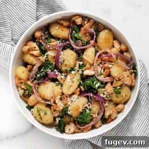 Effortless Sheet Pan Gnocchi, Beans and Kale 6 A beautifully plated bowl of Sheet Pan Gnocchi with White Beans and Kale, garnished with fresh herbs and Parmesan.