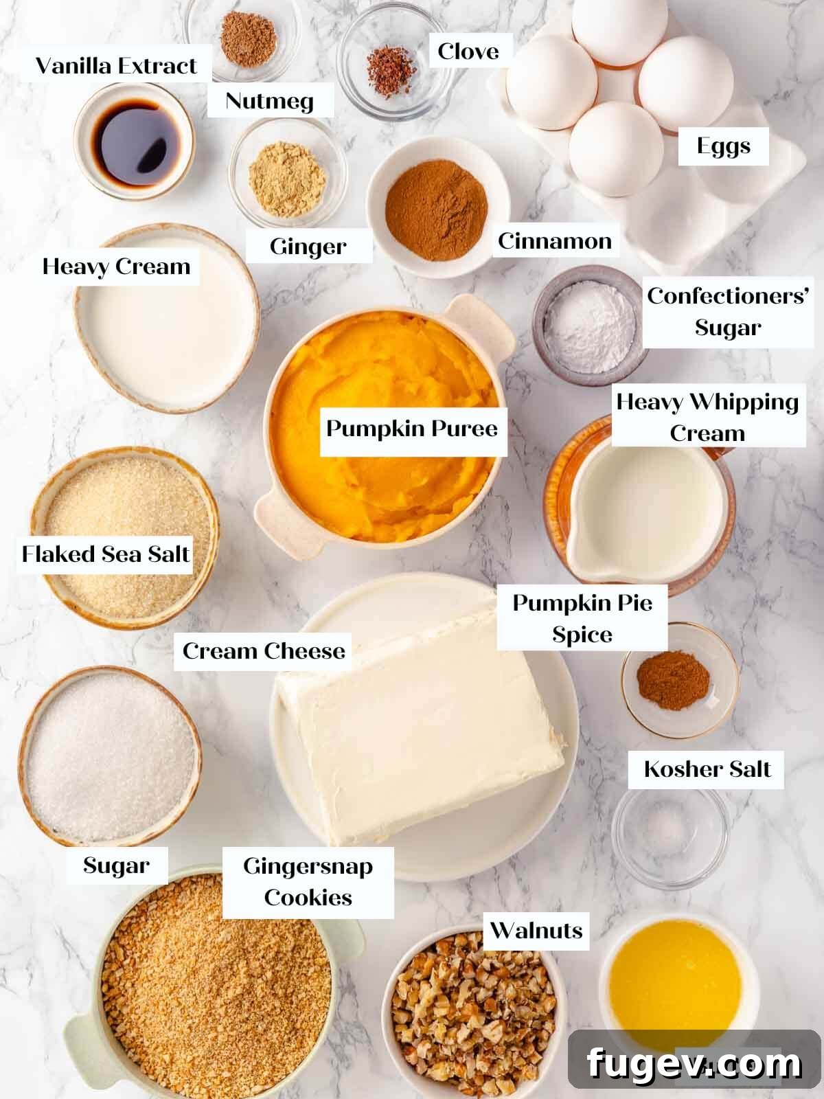 Spiced Pumpkin Cheesecake 4 Pumpkin cheesecake ingredients laid out on a white marble countertop.