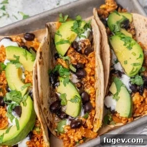 Flavorful chicken taco with creamy avocado and chopped cilantro toppings.