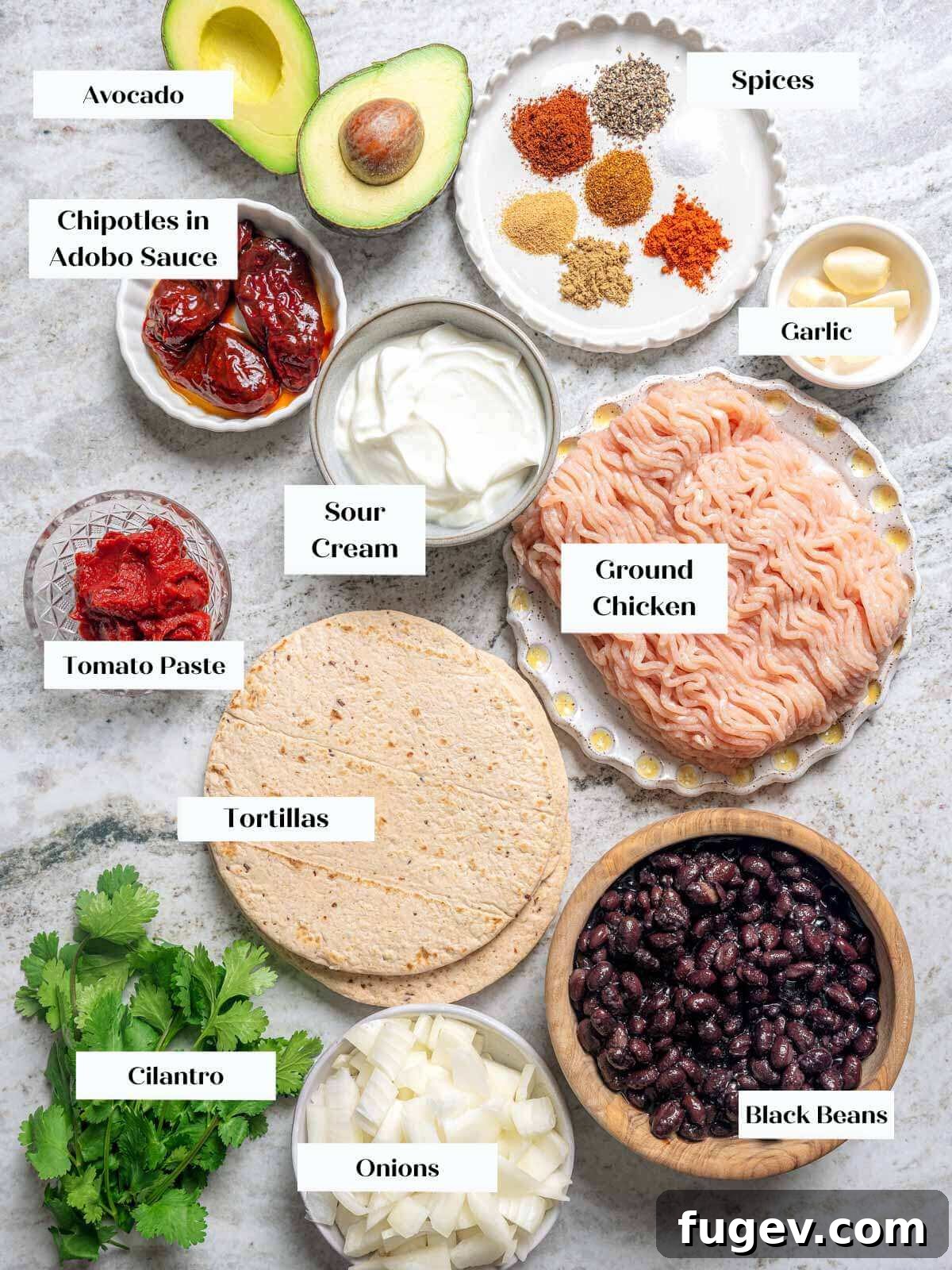 Zesty Ground Chicken Tacos 4 Ground chicken taco ingredients laid out on a marble countertop, including spices, vegetables, and chicken.