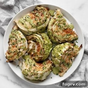 Golden-brown roasted cabbage wedges drizzled with a fresh scallion tahini sauce.