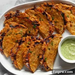 Oven-baked crispy chickpea tacos filled with seasoned smashed chickpeas, shredded red cabbage, and a hint of cheese.