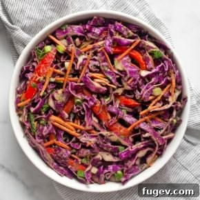 Creamy Red Cabbage Slaw with bell peppers and carrots, tossed in a rich, no-mayo avocado dressing.