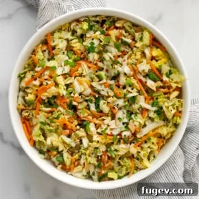 Crisp Napa cabbage salad with shredded carrots, cilantro, and roasted peanuts, dressed in a savory peanut ginger vinaigrette.