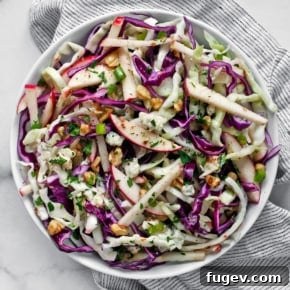Refreshing Apple Cabbage Salad with red and green cabbage, pink lady apples, crumbled blue cheese, and toasted walnuts.