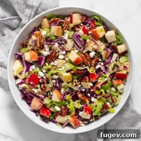 Savory Apple Pecan Salad with chopped cabbage and romaine, spiced pecans, and a sweet and spicy dressing.