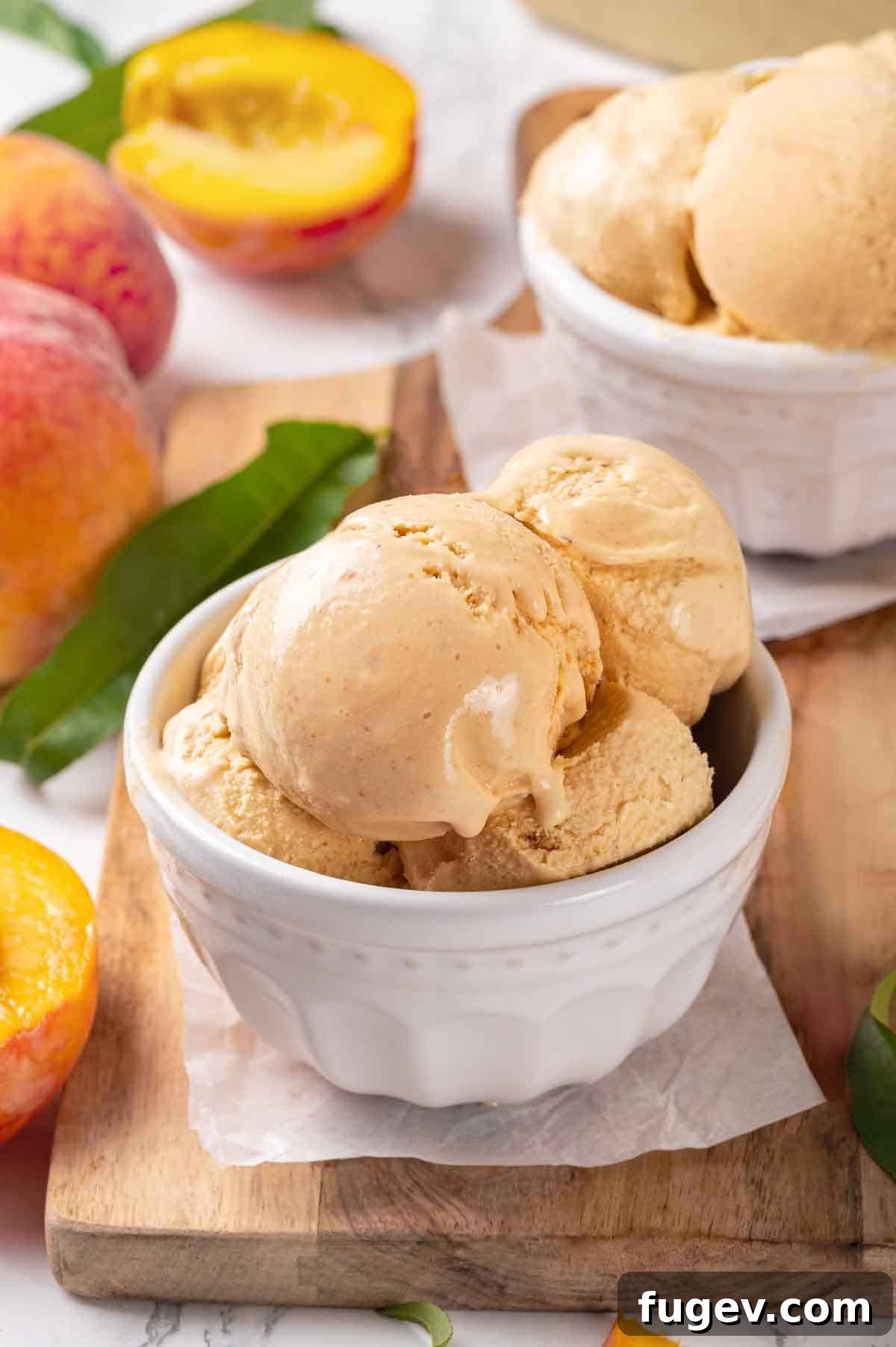 Luscious Peach Ice Cream 3 Close-up of scoops of fresh peach ice cream in a white bowl, showing its creamy texture.