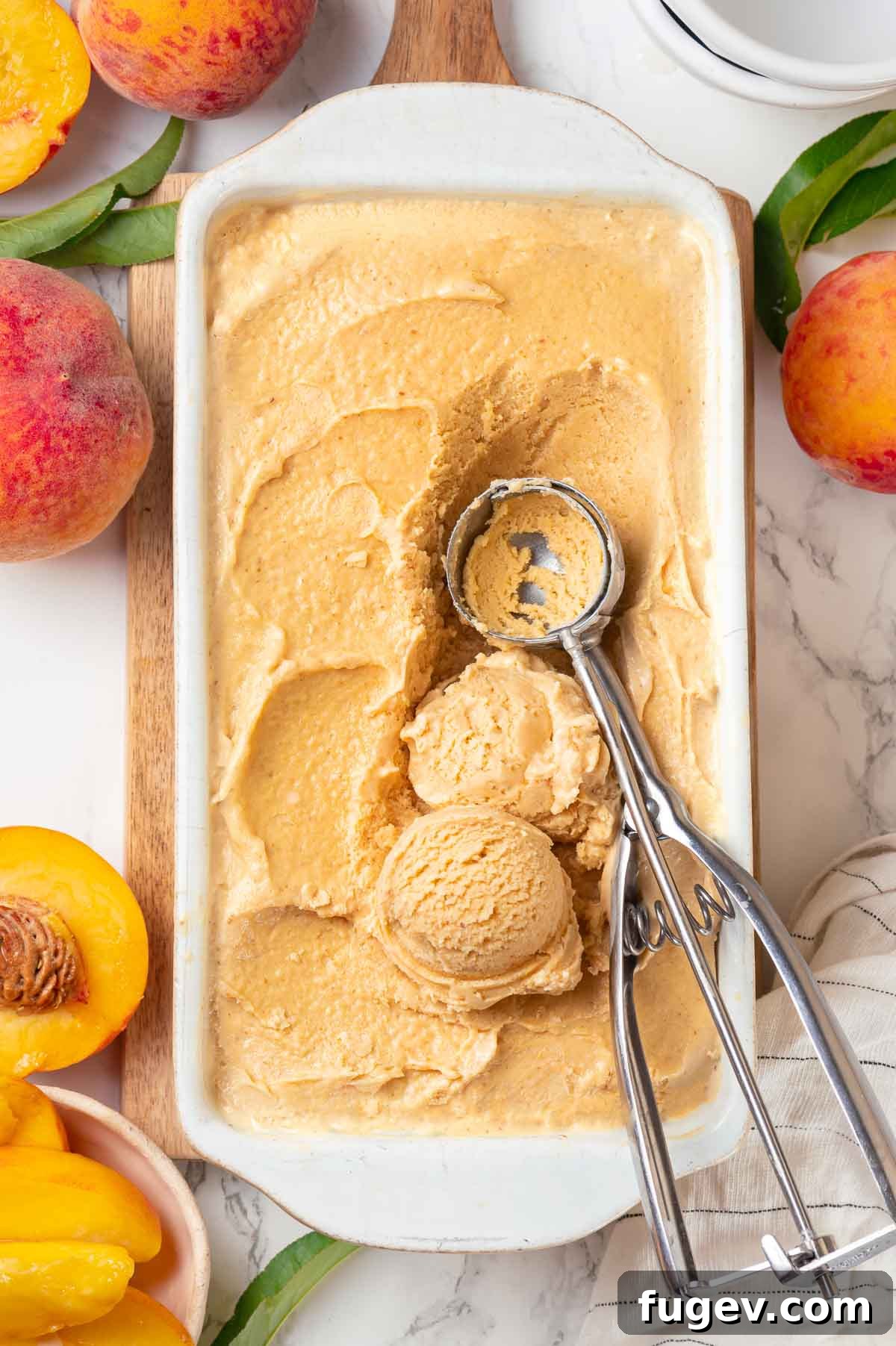 Luscious Peach Ice Cream 5 Scoops of fresh peach ice cream in a white loaf pan, alongside a vintage ice cream scoop.
