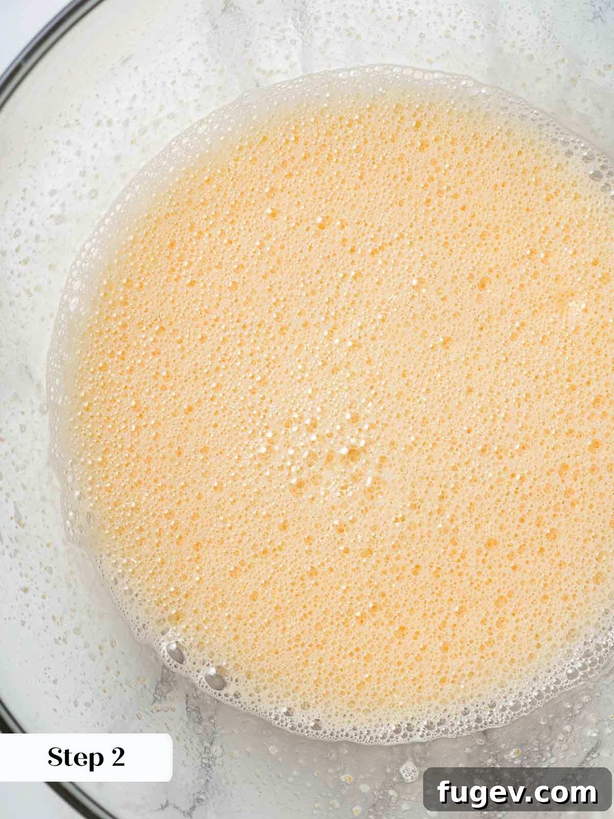 Luscious Peach Ice Cream 6 Whisked eggs and sugar mixture in a bowl, showing a pale yellow color.
