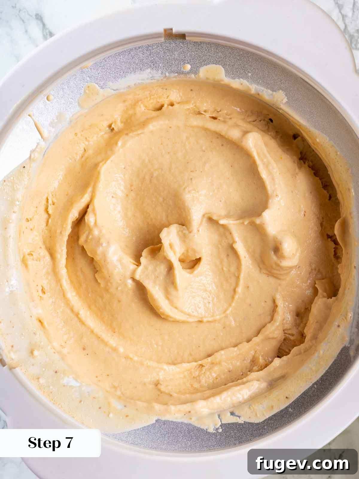 Luscious Peach Ice Cream 9 Churned peach ice cream inside an ice cream maker bowl, still soft.