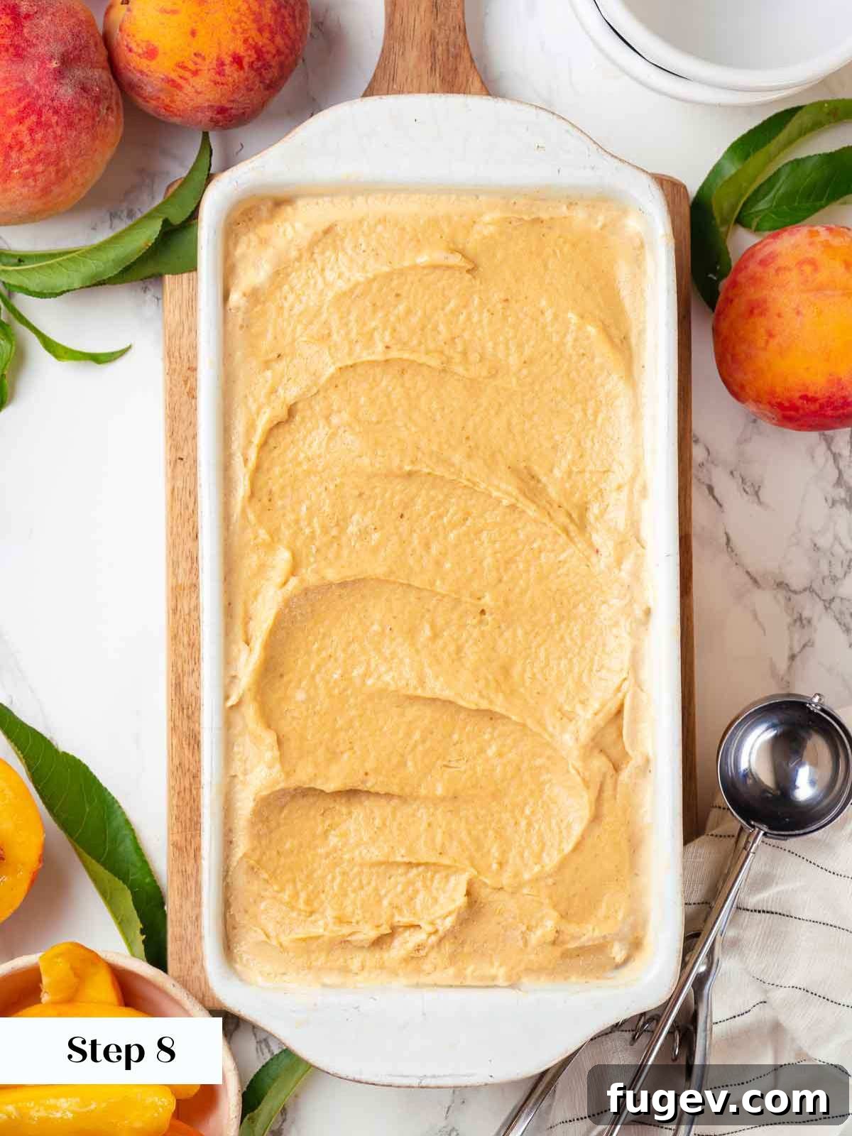 Luscious Peach Ice Cream 10 Freshly churned peach ice cream smoothed into a container, ready for freezing.