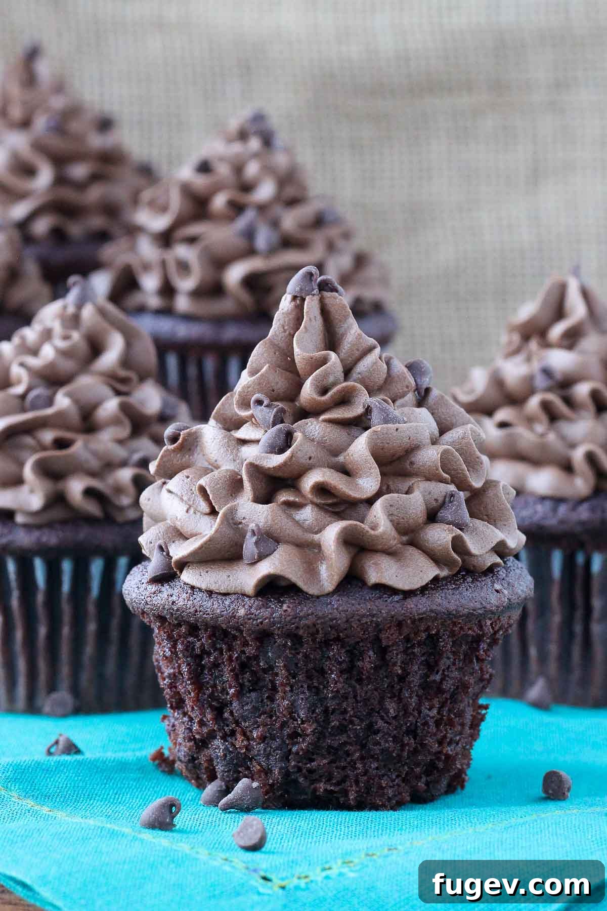 Decadent Chocolate Cupcakes 2 Decadent chocolate cupcake with rich chocolate frosting on a teal napkin, highlighting its irresistible appeal.