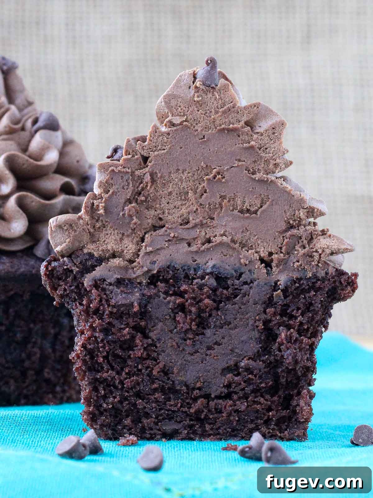 Decadent Chocolate Cupcakes 4 A chocolate cupcake expertly cut in half, revealing a generous, gooey chocolate ganache filling inside.