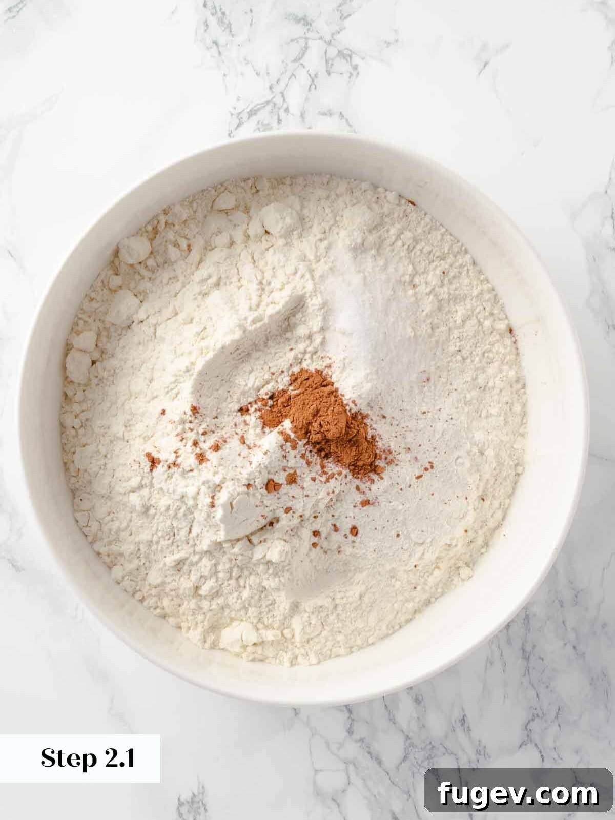 Harvest Apple Cider Donuts 6 A whisk blending dry ingredients, including flour, baking powder, salt, and cinnamon, in a large white bowl for the donut dough.