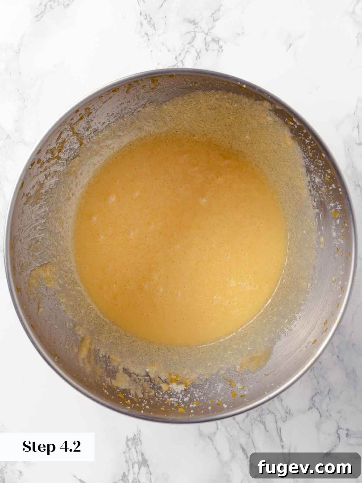 Harvest Apple Cider Donuts 9 Egg yolks being slowly added to the creamed butter and sugar mixture in a stand mixer, creating a smooth batter.