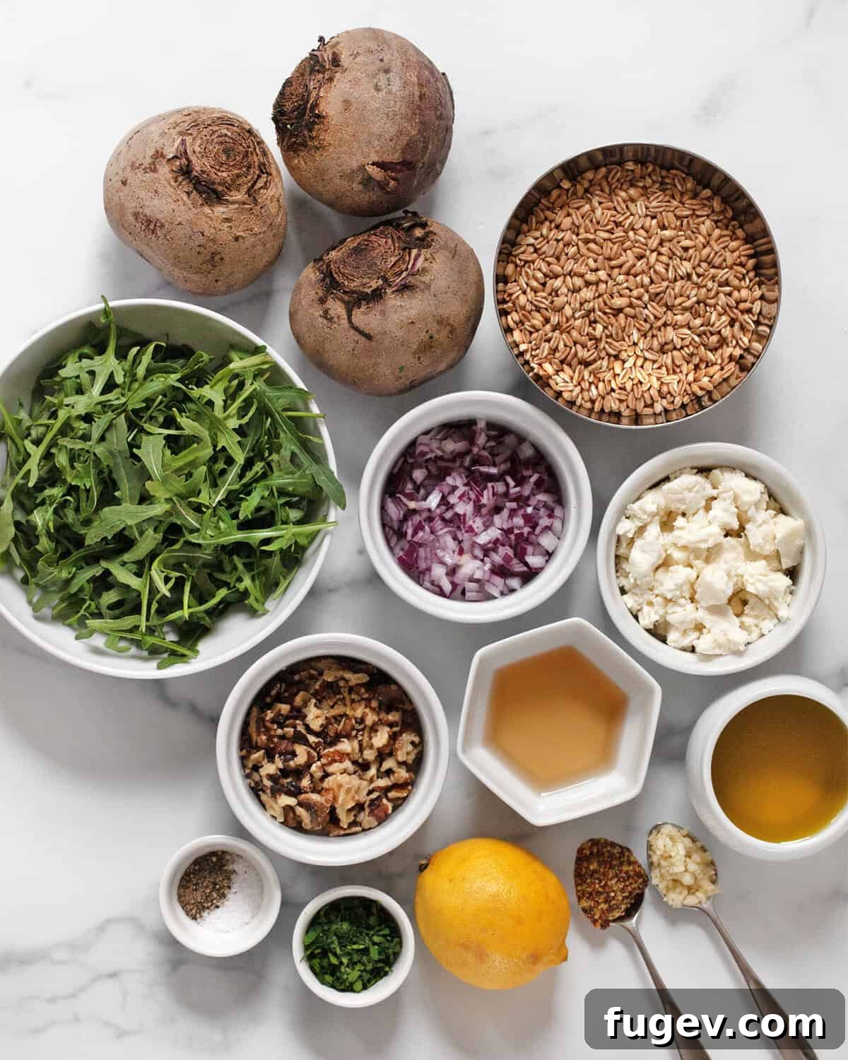 Mediterranean Farro Delight with Roasted Beets and Crumbled Feta 3 A flat lay of fresh ingredients for beet feta farro salad: beets, feta, farro, arugula, red onions, walnuts, parsley, olive oil, garlic, and mustard.