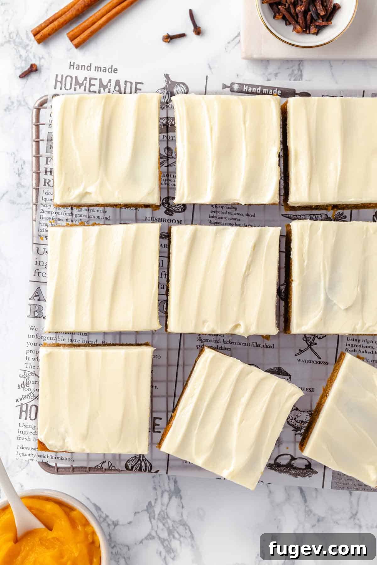 Autumn Pumpkin Spice Squares 17 Beautifully frosted and sliced pumpkin bars arranged artistically on a pristine white marble counter, ready to be enjoyed.