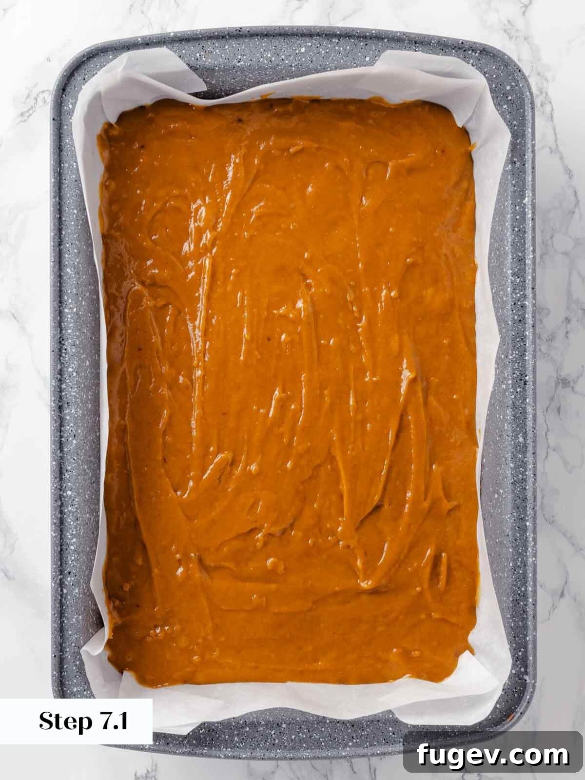 Autumn Pumpkin Spice Squares 10 The smooth pumpkin bar batter is carefully spread into a parchment-lined baking dish with an offset spatula, ready for baking.