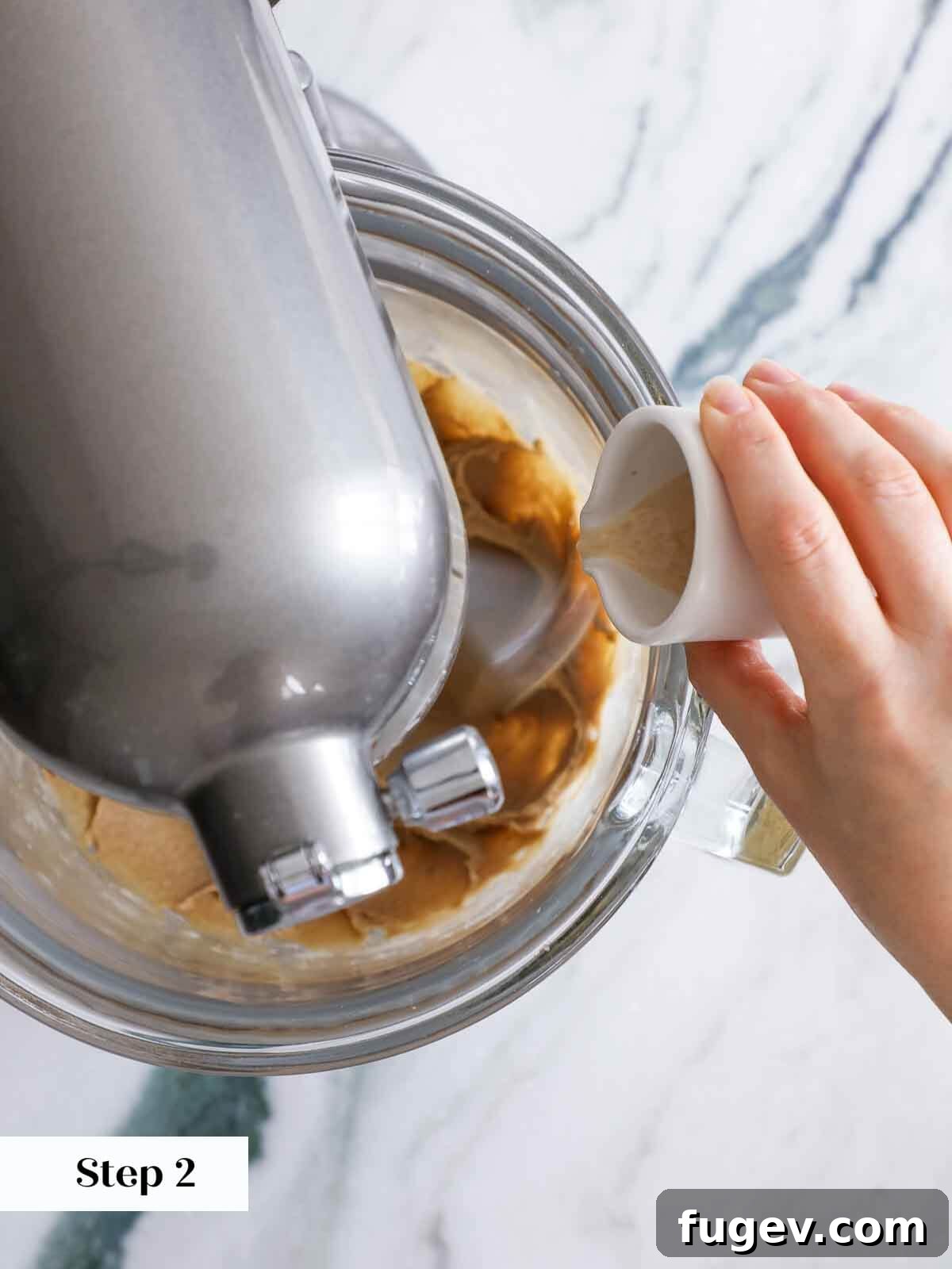 Sparkling Cinnamon Delights 5 A close-up view of the stand mixer bowl as eggs and vanilla extract are being added to the creamy butter and brown sugar mixture, mid-preparation.