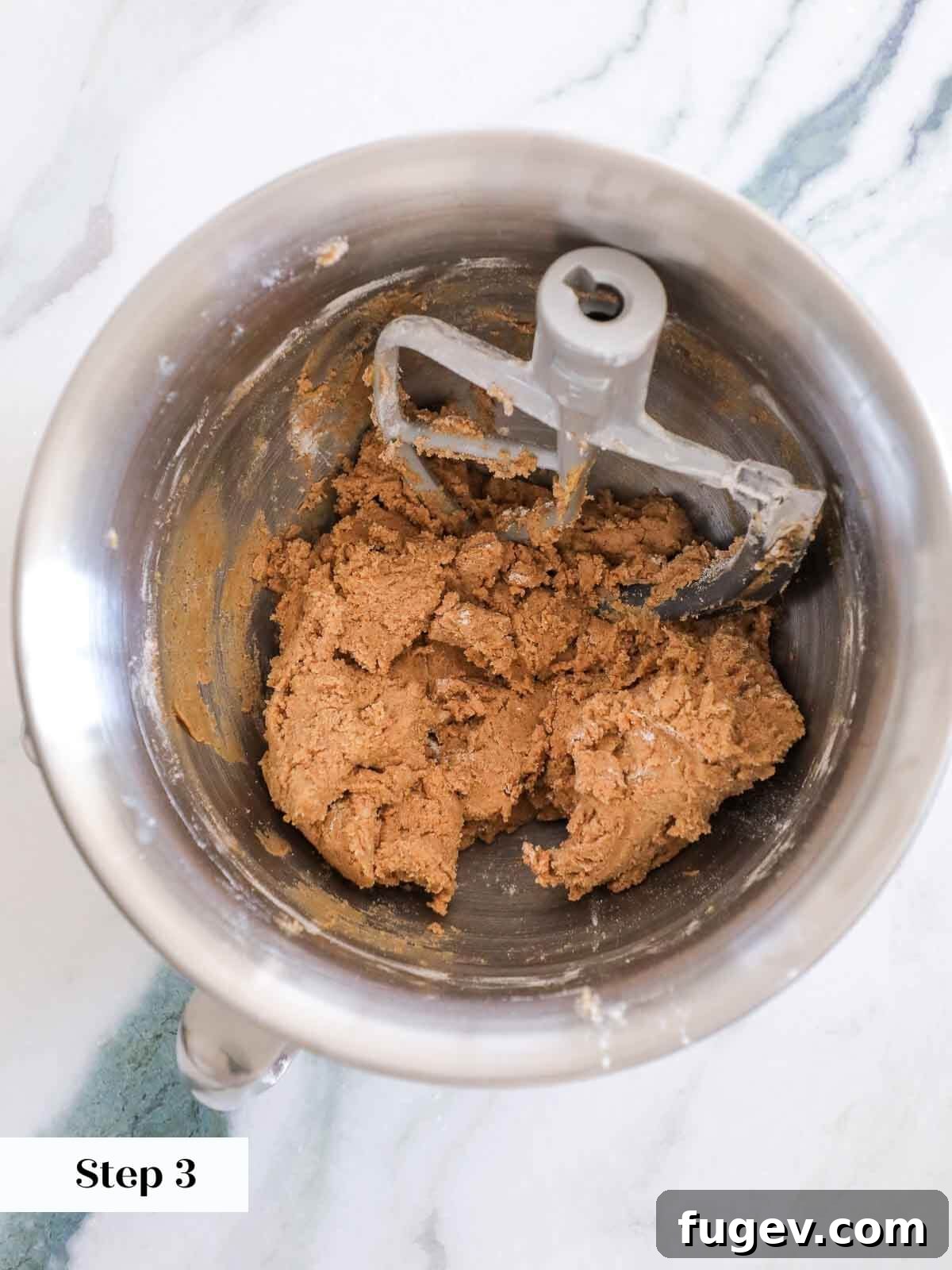 Sparkling Cinnamon Delights 6 The fully mixed cinnamon sugar cookie dough, showcasing its rich brown color and ready consistency, resting in a stand mixer bowl.
