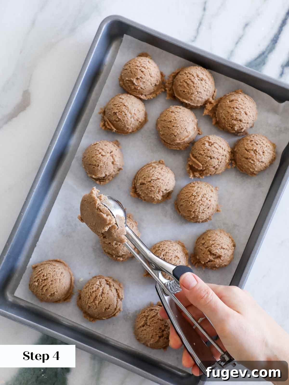 Sparkling Cinnamon Delights 7 The organized process of portioning perfectly shaped cinnamon sugar cookie dough balls onto a baking sheet lined with parchment paper.