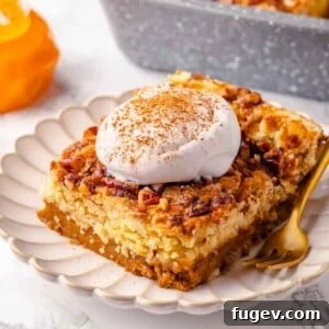A slice of pumpkin dump cake topped with a generous dollop of whipped cream, artfully presented on a white plate, invitingly ready to be enjoyed.
