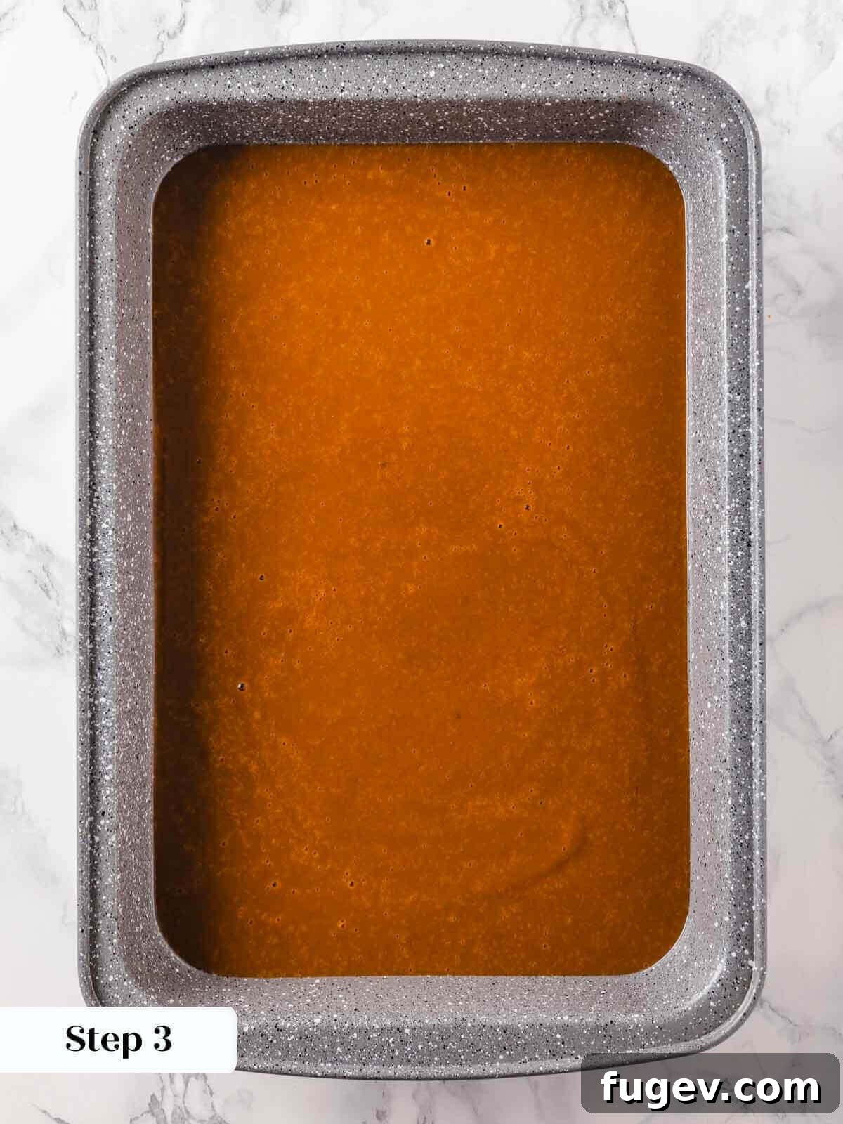 No-Fuss Pumpkin Dump Cake 7 The smooth pumpkin dump cake mixture evenly spread out in a prepared 9x13 inch baking dish, forming the base layer.