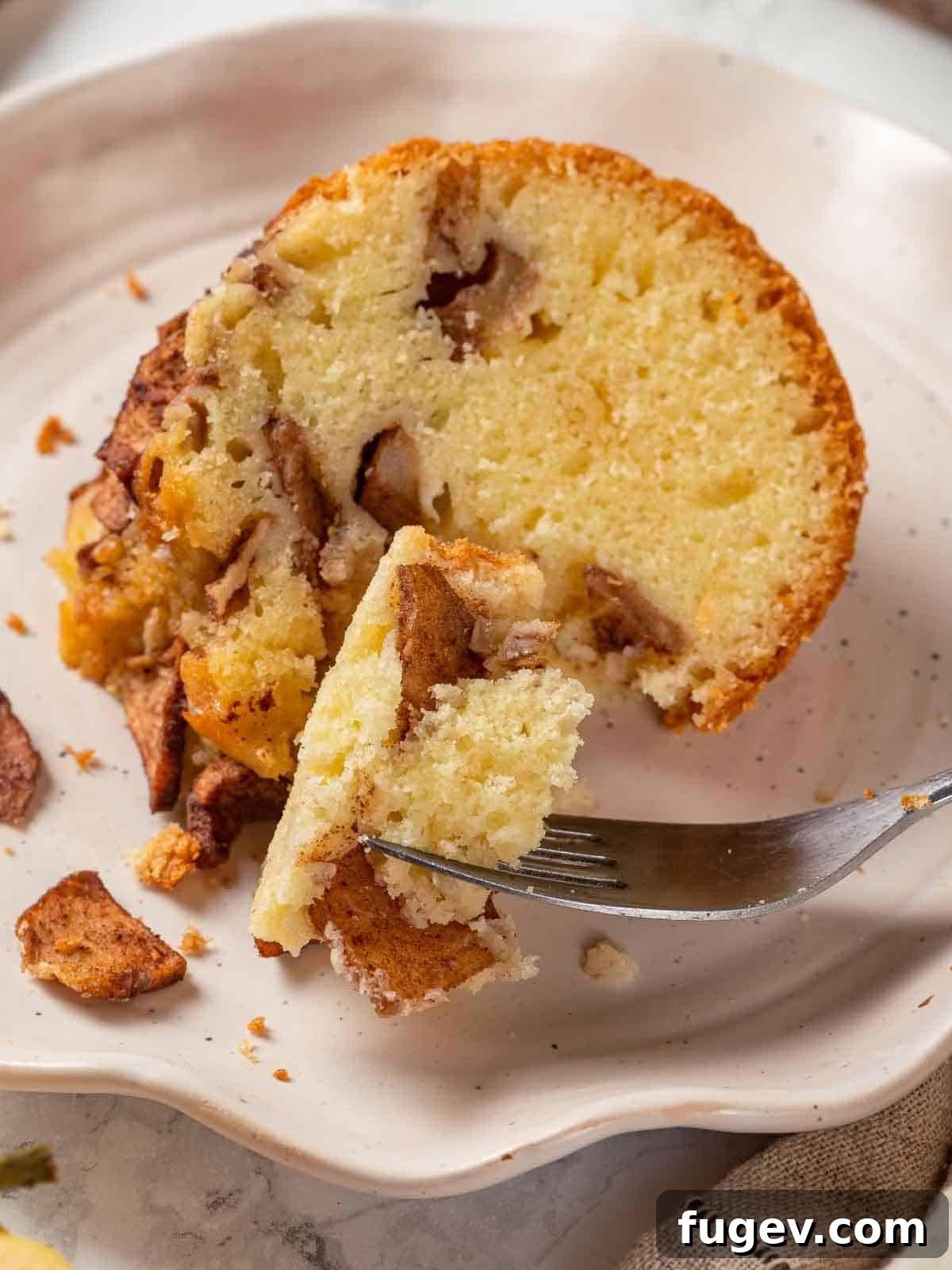 Grandma's Jewish Apple Cake 12 A single, perfectly cut slice of Jewish apple cake, showcasing its beautiful layers of cake and baked apples.