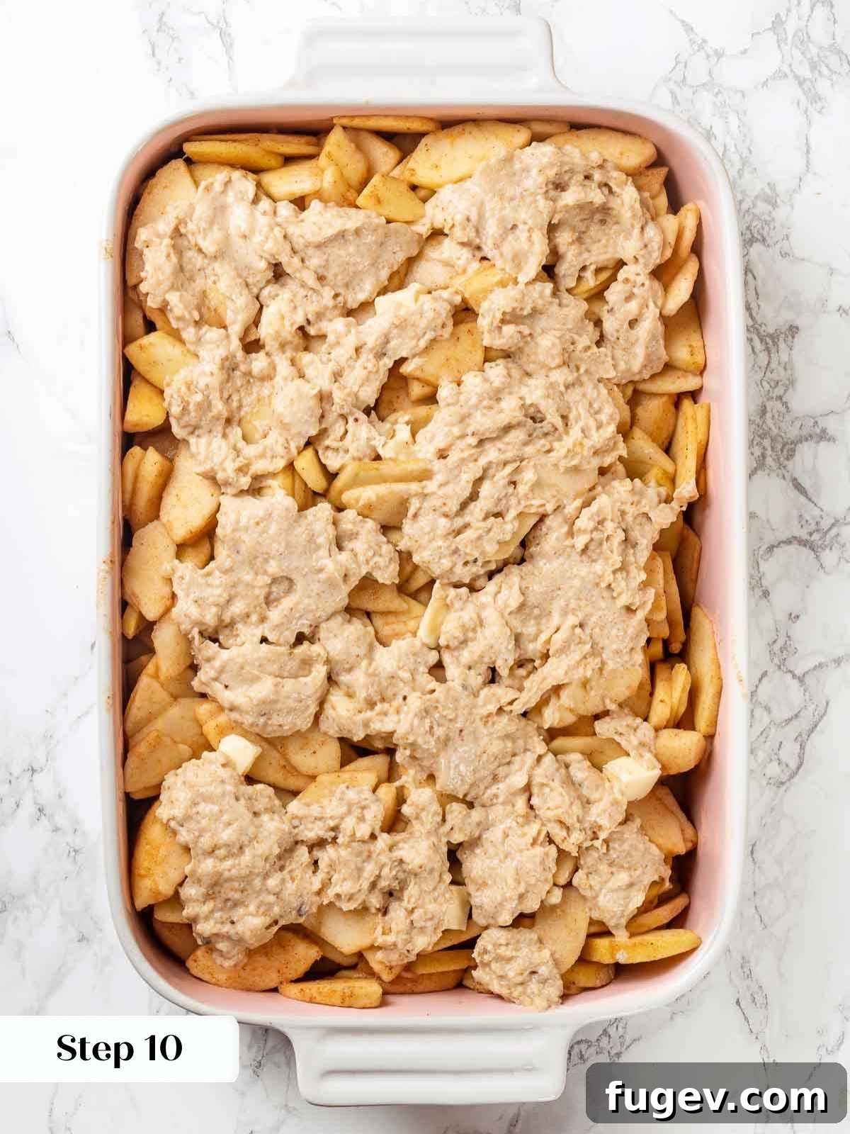 Cozy Apple Cobbler Magic 11 The assembled apple cobbler before baking, showing the raw apple filling topped with dollops of biscuit dough in a baking dish, ready for the oven.