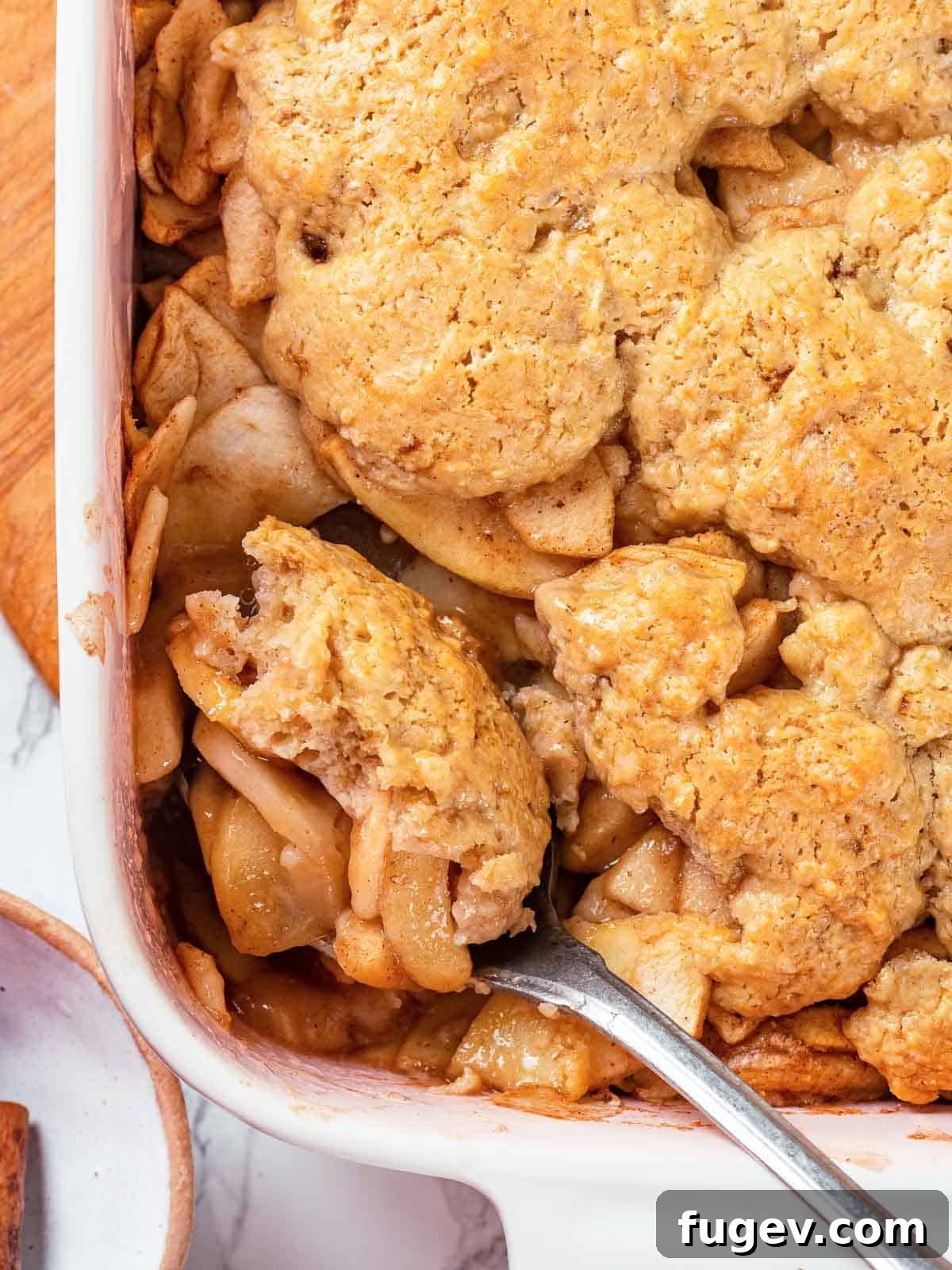 Cozy Apple Cobbler Magic 13 A perfectly baked apple cobbler with a glistening, golden brown biscuit topping, ready to be portioned and served, showcasing its appetizing appeal.