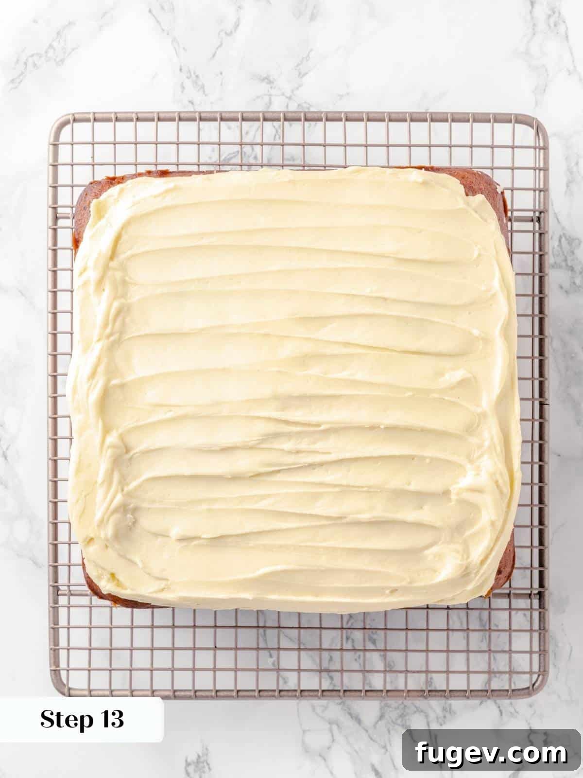 Frosted applesauce cake cooling on a wire rack.