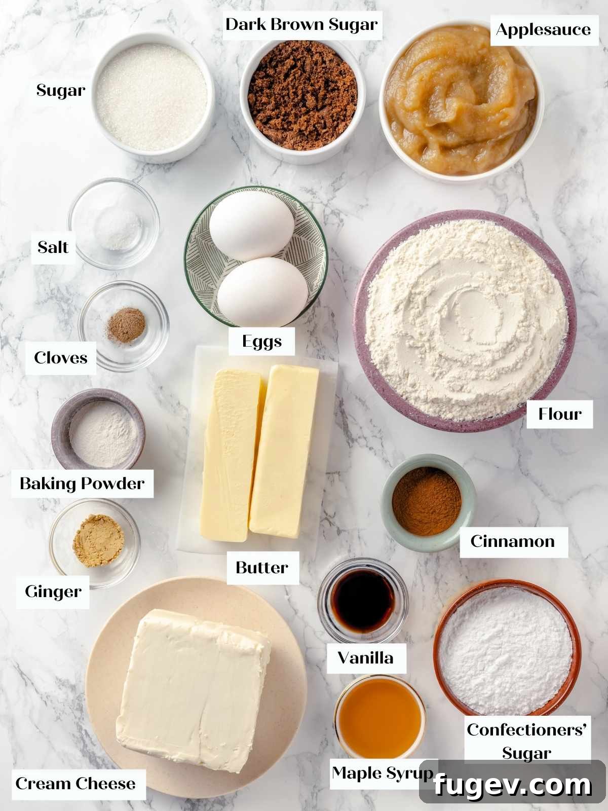 Ingredients for applesauce cake arranged on a white marble countertop.