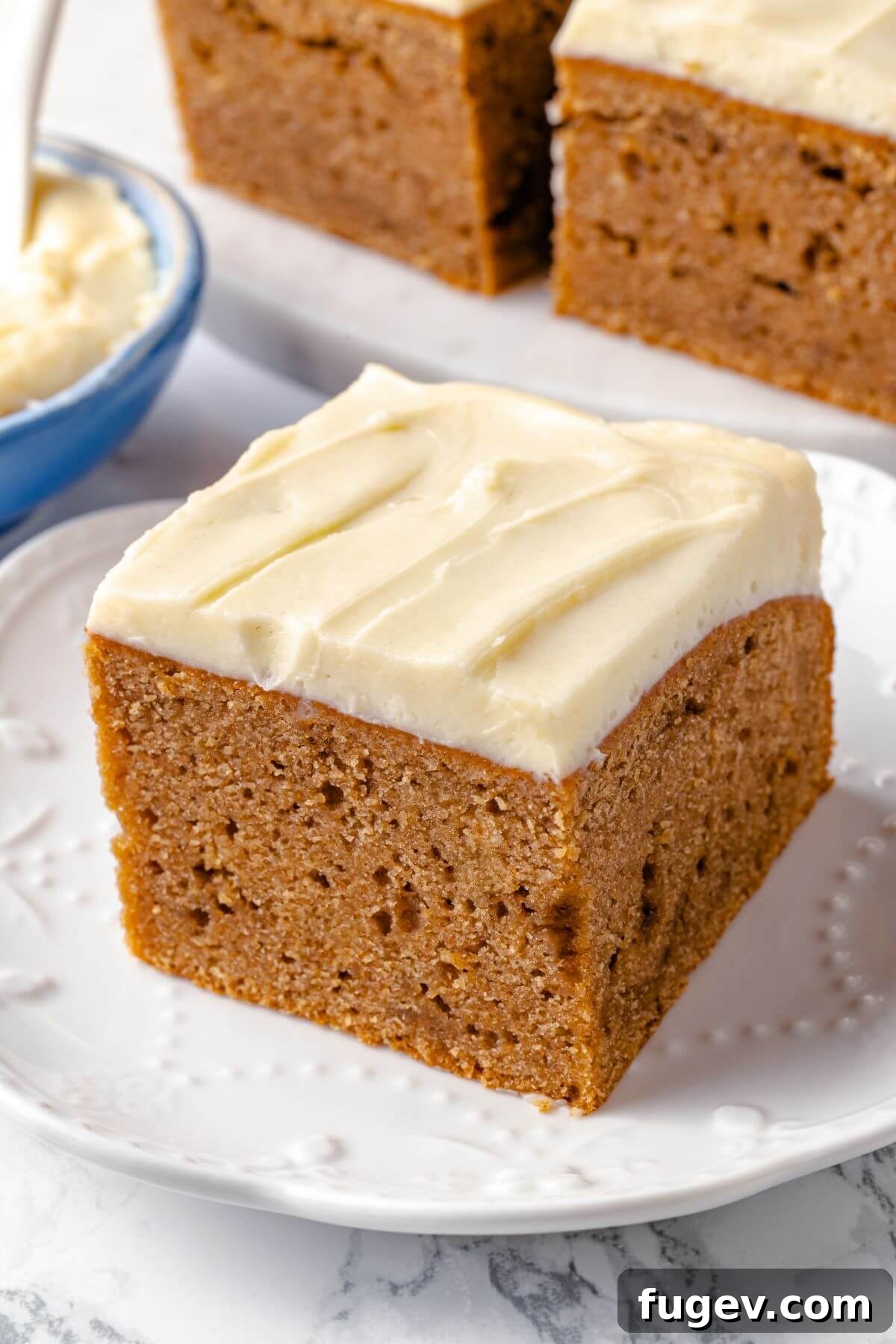 A slice of applesauce cake served on a white plate.