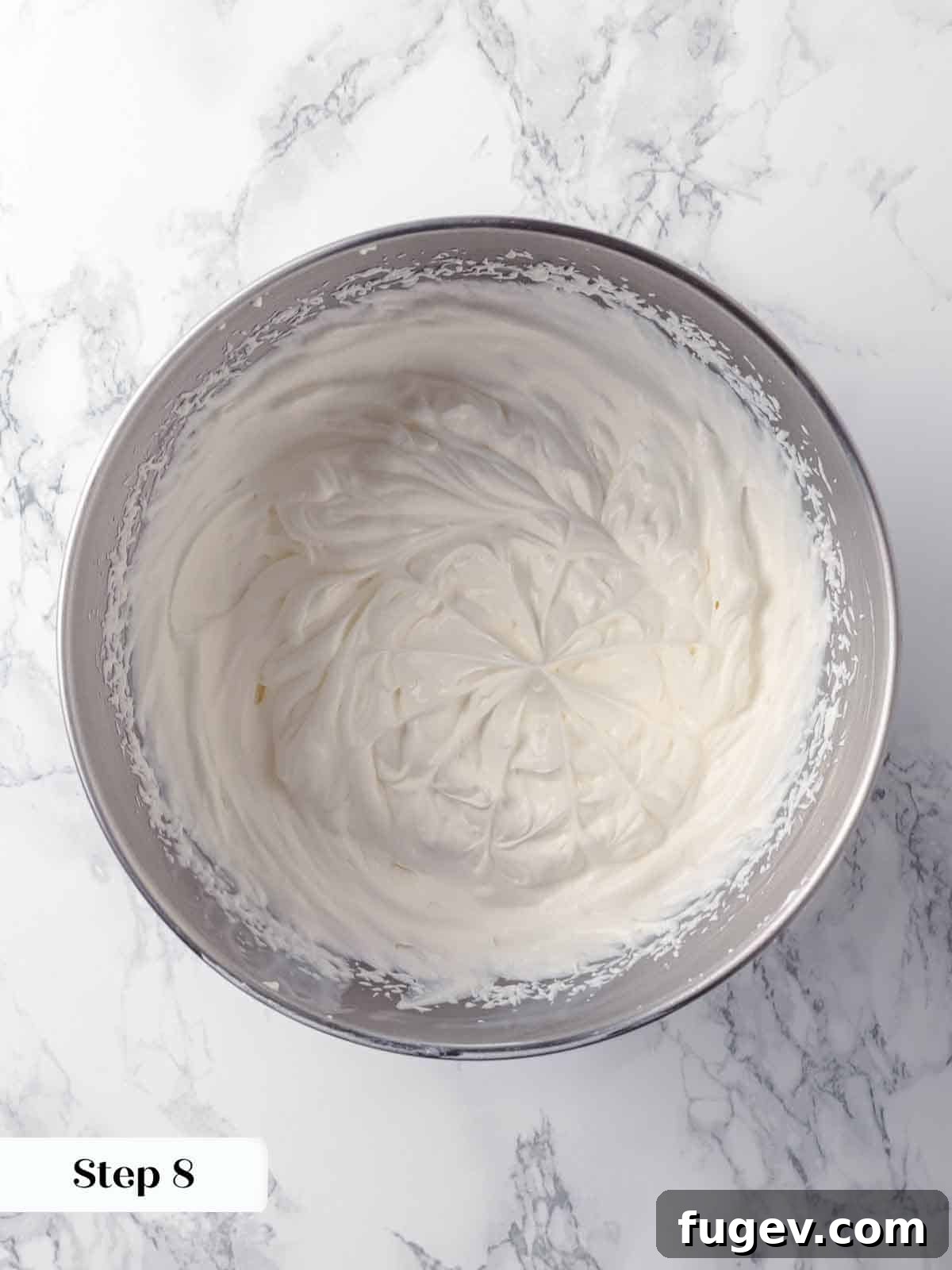 Luscious Coconut Cream Pie 13 Fresh heavy cream being whipped to stiff peaks with confectioners' sugar and vanilla extract, creating the luxurious topping for the coconut cream pie.