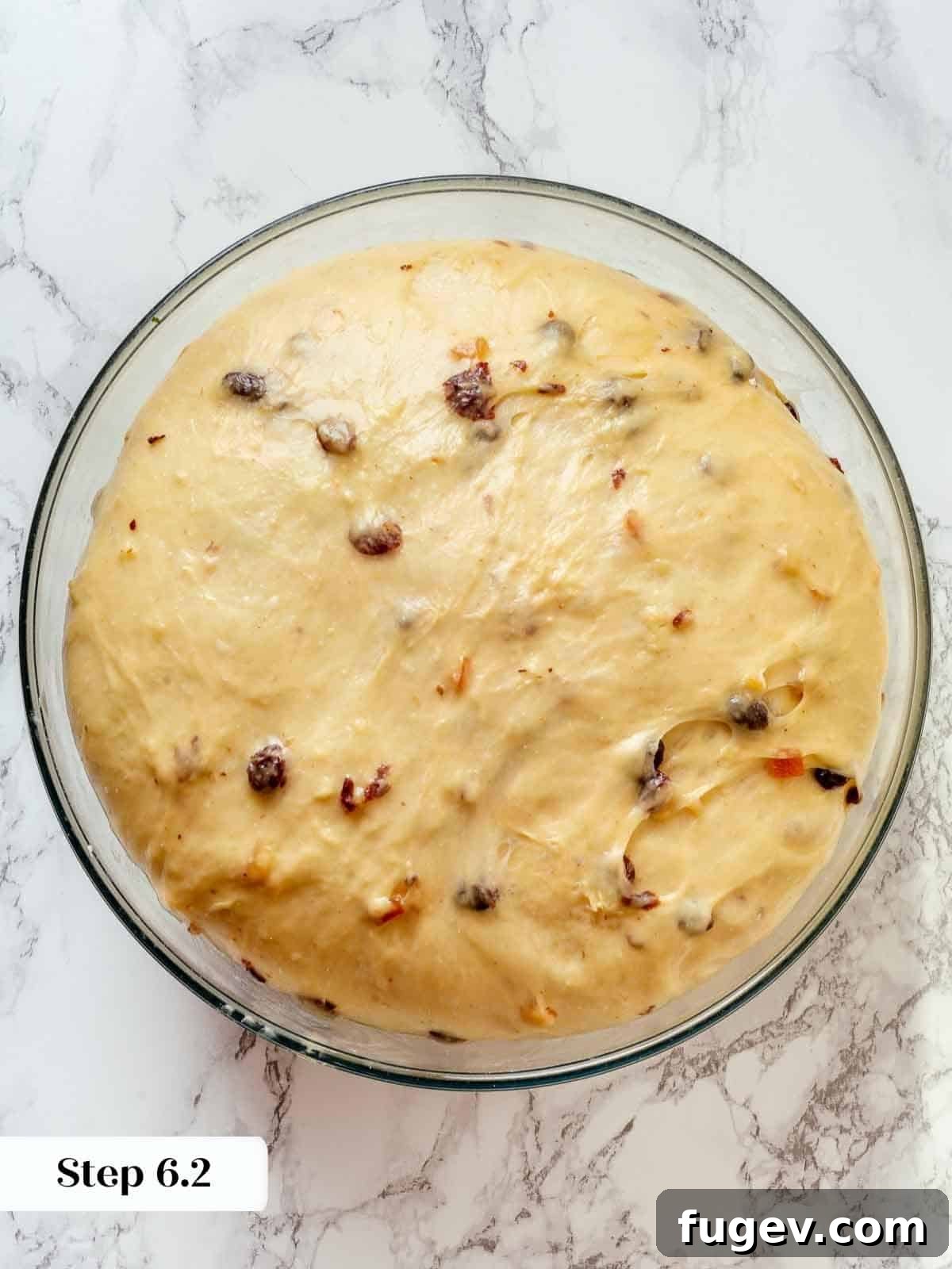 Traditional Italian Panettone 11 Panettone dough visibly proofing inside a clear glass bowl, showing its increased volume and airy texture.