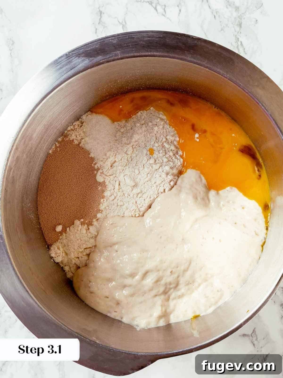 Traditional Italian Panettone 6 Egg yolks and dry ingredients being mixed together in a stand mixer bowl, marking the initial stage of dough preparation.