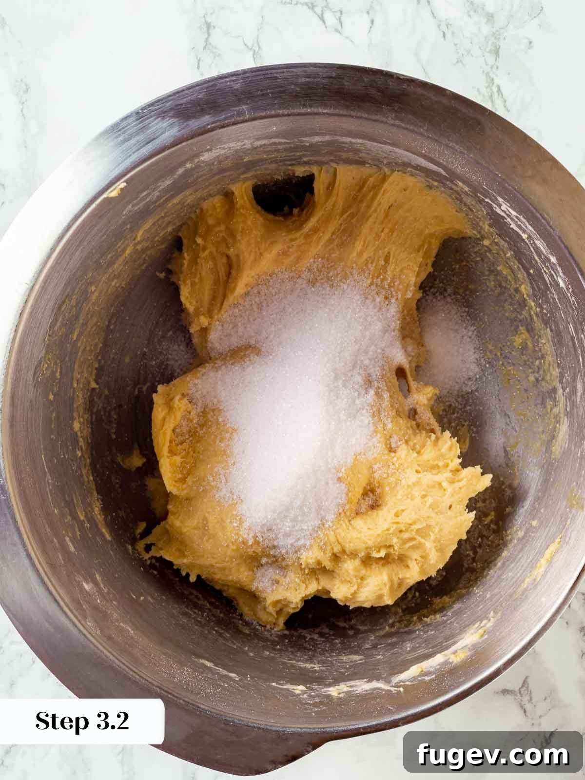 Traditional Italian Panettone 7 Granulated sugar being slowly added in batches to the panettone dough in a stand mixer, ensuring even incorporation.