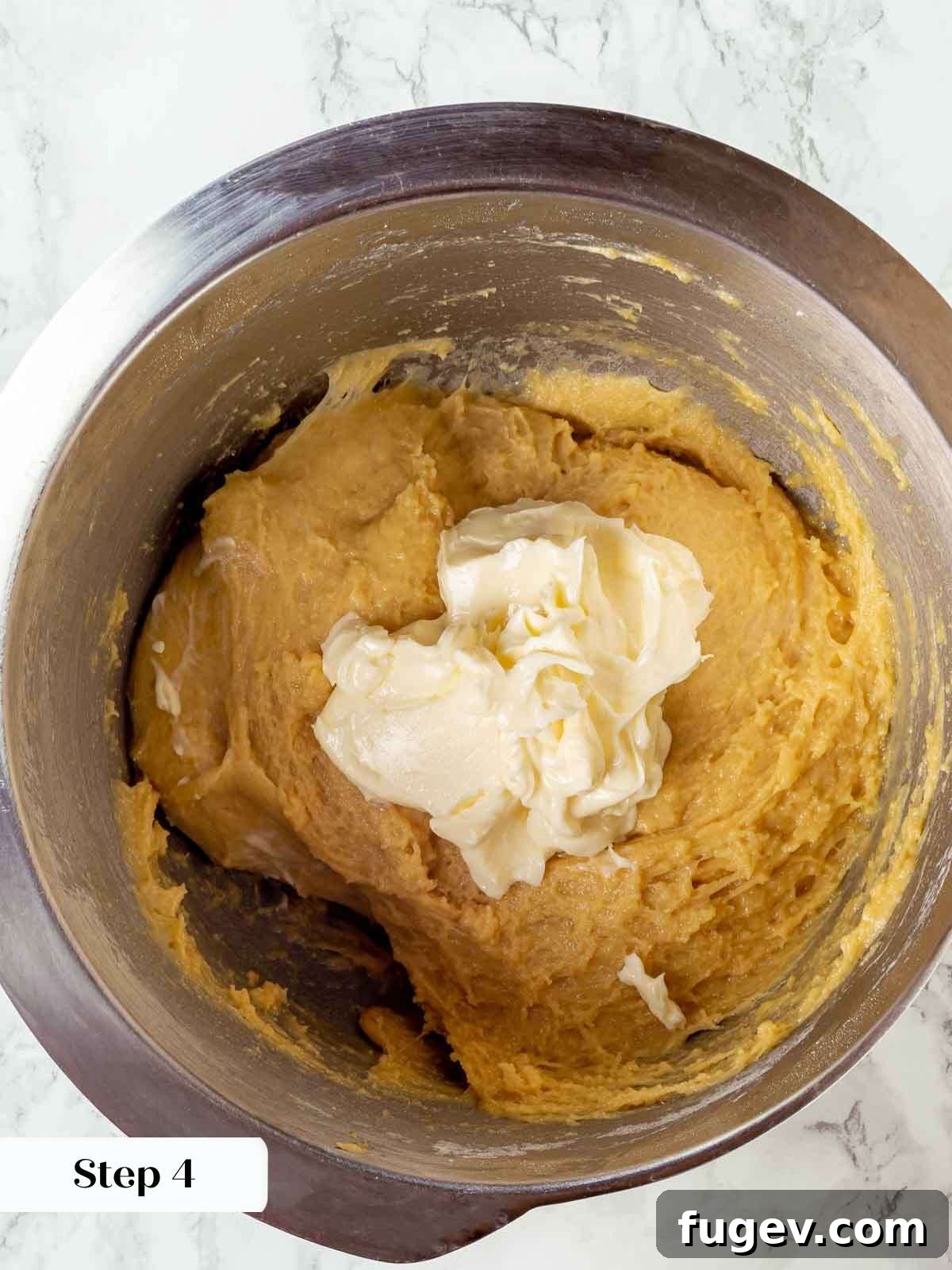 Traditional Italian Panettone 8 Softened butter being gradually incorporated into the rich panettone dough during the mixing process.