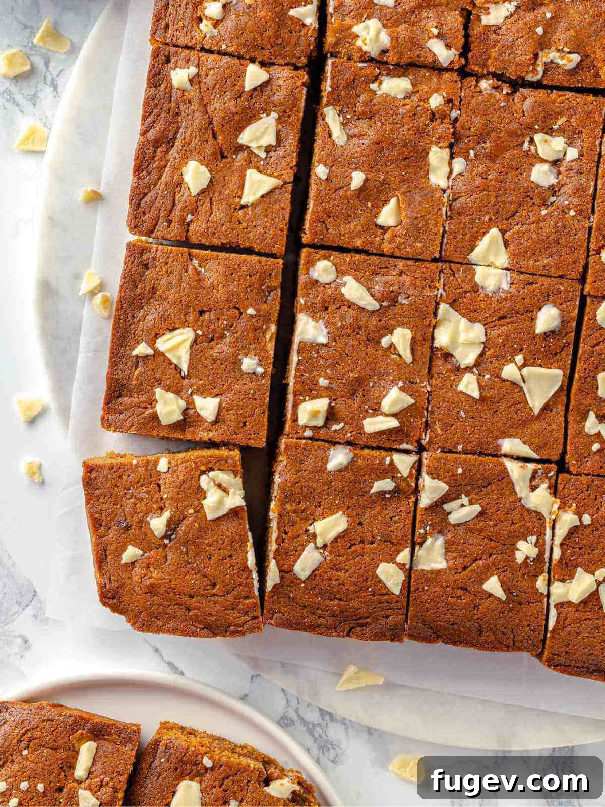 Chewy Gingerbread Blondies 12 A close-up of fully baked gingerbread blondies in a metal pan, showing their golden-brown edges and slightly puffed centers, signaling they are perfectly done.