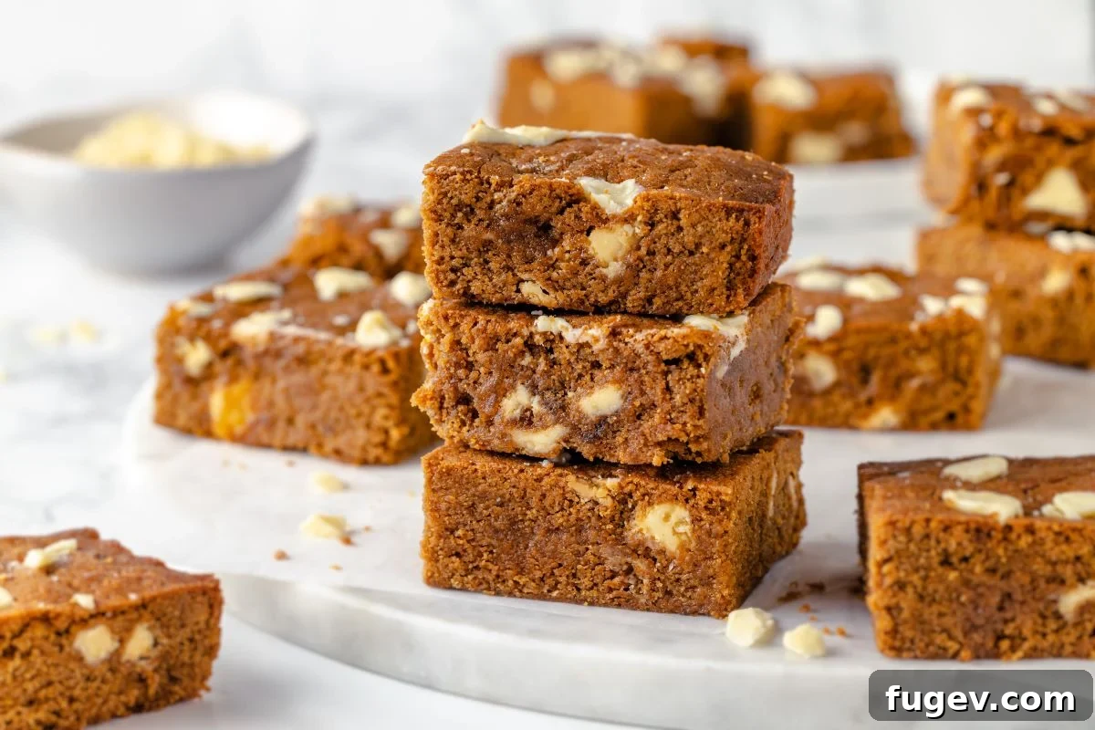 Chewy Gingerbread Blondies 3 A batch of freshly baked and cooled gingerbread blondies, neatly cut into perfect squares, ready to be served or packed for a holiday gift.