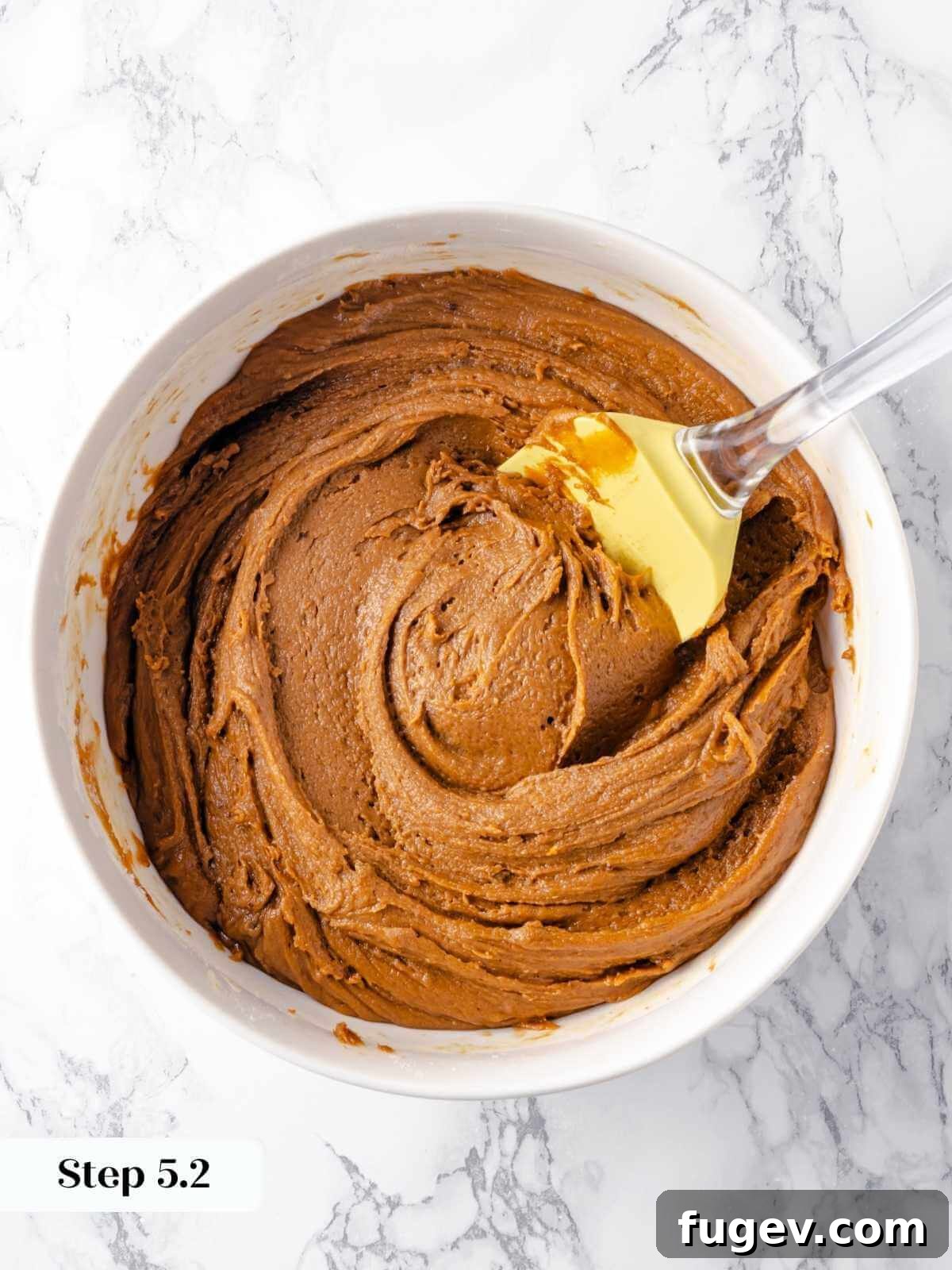 Chewy Gingerbread Blondies 9 The fully mixed gingerbread blondie batter, rich and smooth, nestled in a mixing bowl, ready to be poured into the prepared baking pan.