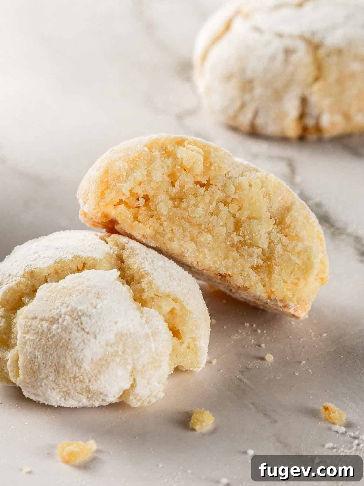 Italian Almond Amaretti 2 Close-up of a stack of soft amaretti cookies, perfectly round and coated in powdered sugar with visible crinkles.