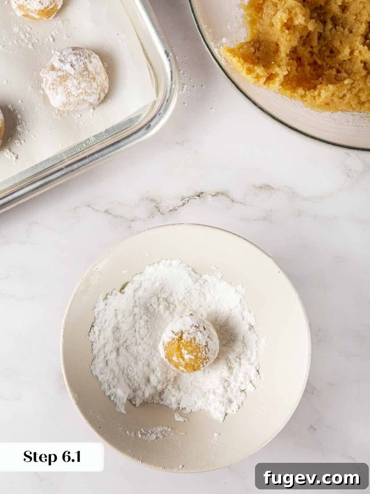 Italian Almond Amaretti 9 Amaretti cookie dough balls being rolled generously in powdered sugar.