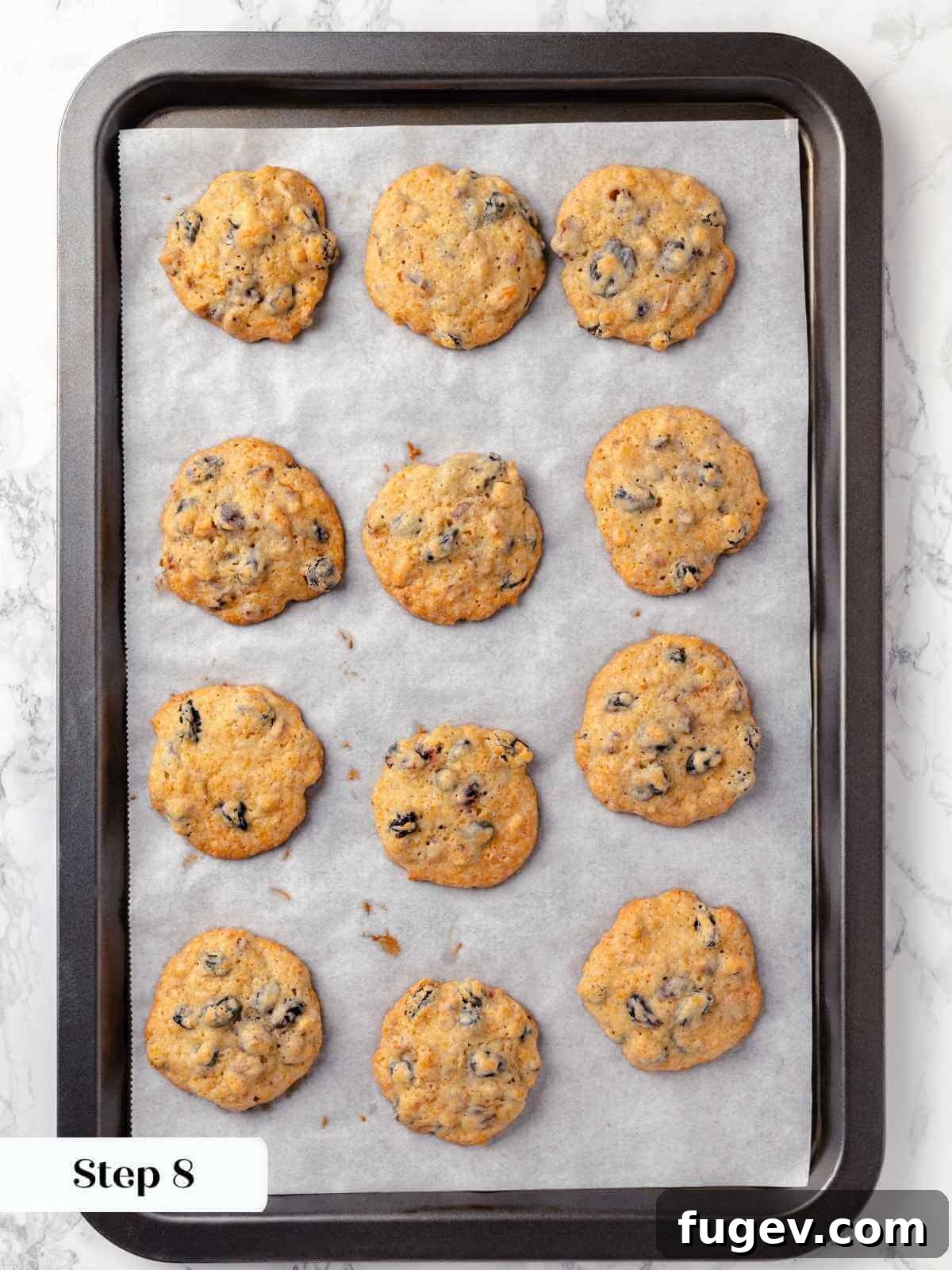 Old Fashioned Spiced Hermit Bars 16 Hermit cookies fresh out of the oven, golden and slightly puffy on a baking sheet.
