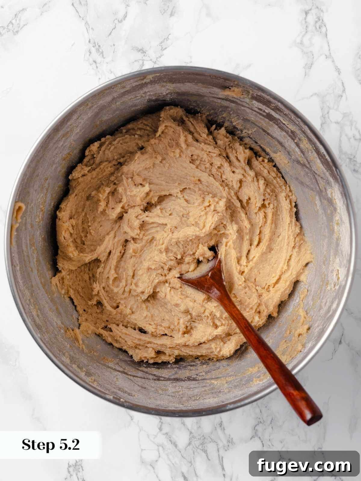 Hearty Cowboy Cookies 12 The cookie dough in a mixing bowl, showcasing the dry ingredients fully incorporated into the wet mixture, forming a cohesive and pliable batter.