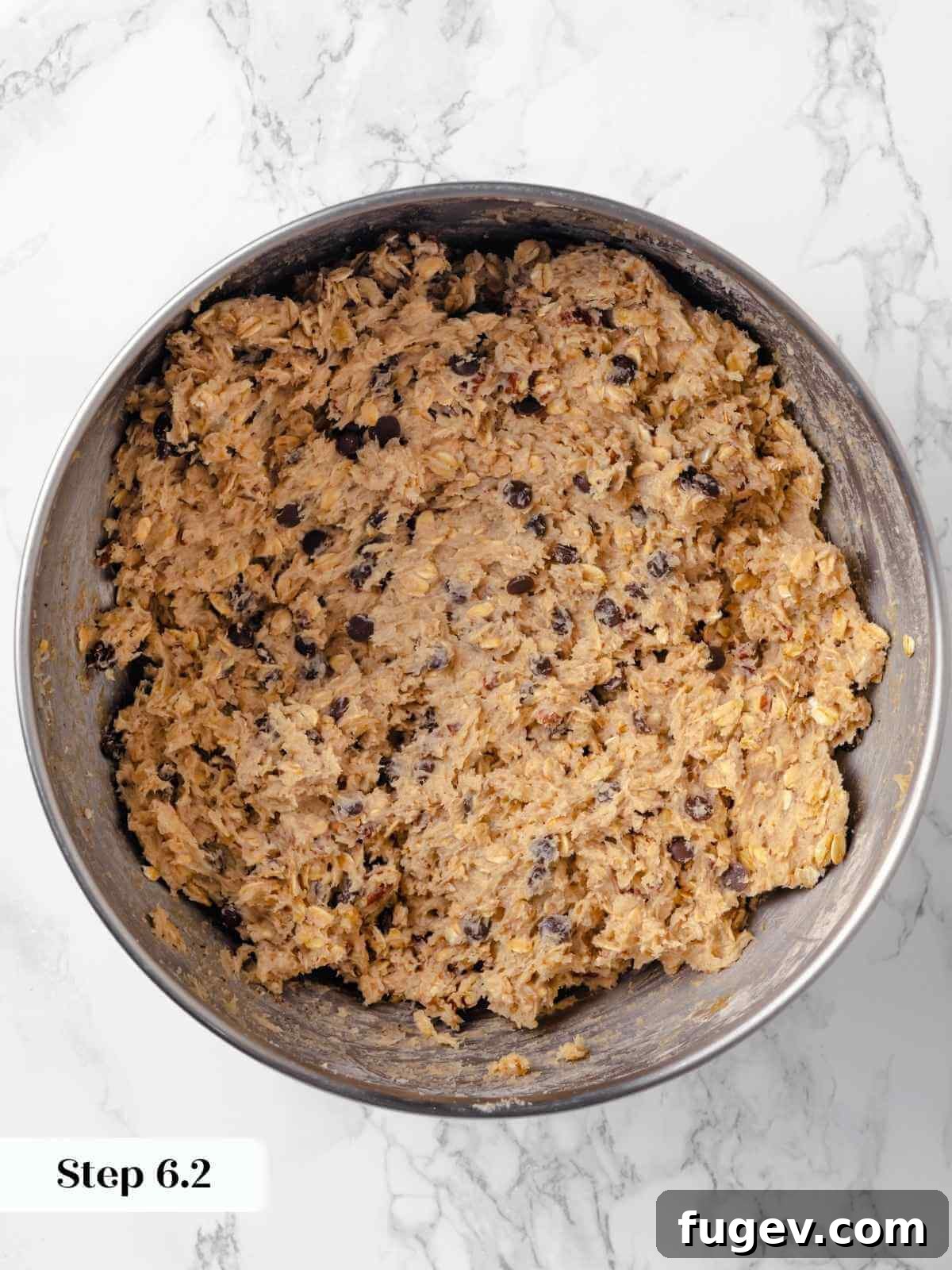 Hearty Cowboy Cookies 14 A rich cookie dough mixture in a bowl, with chocolate chips, oats, and pecans perfectly folded in, ensuring even distribution throughout the batter.