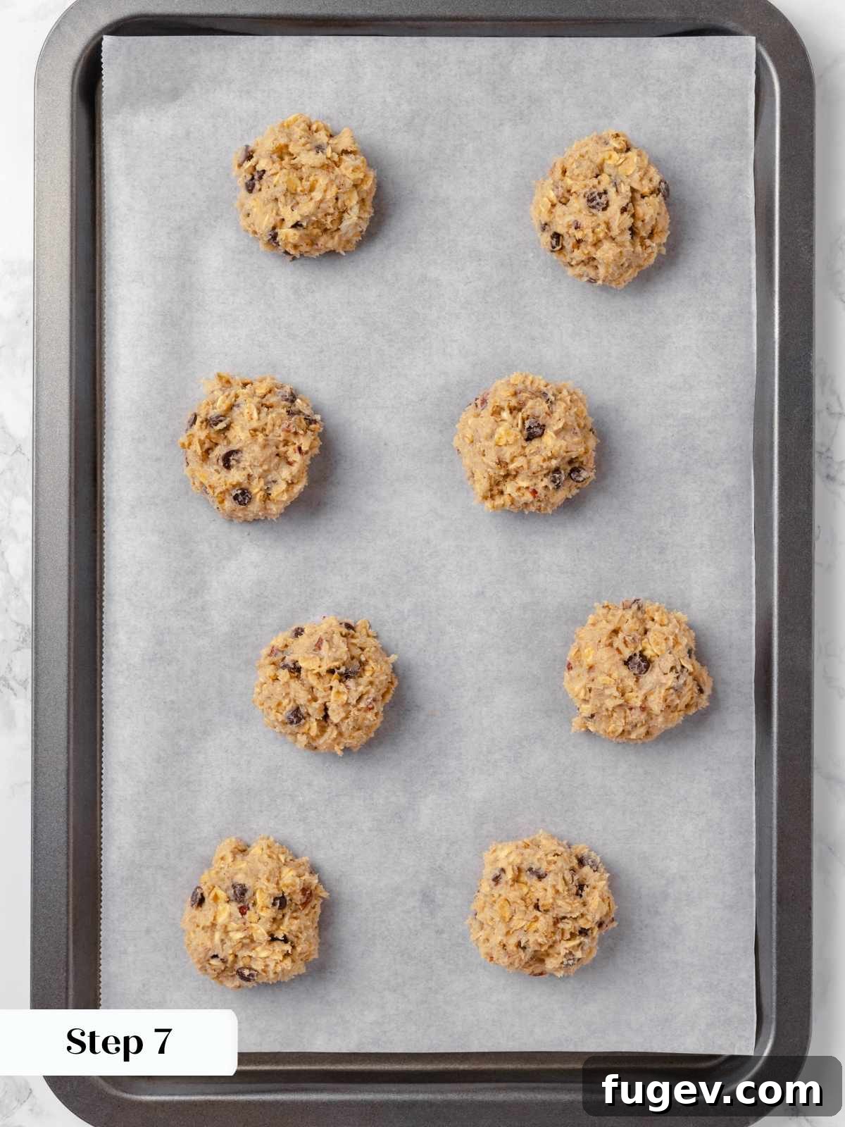 Hearty Cowboy Cookies 15 Perfectly portioned cookie dough balls, arranged neatly and spaced evenly on a parchment-lined baking tray, ready for baking.