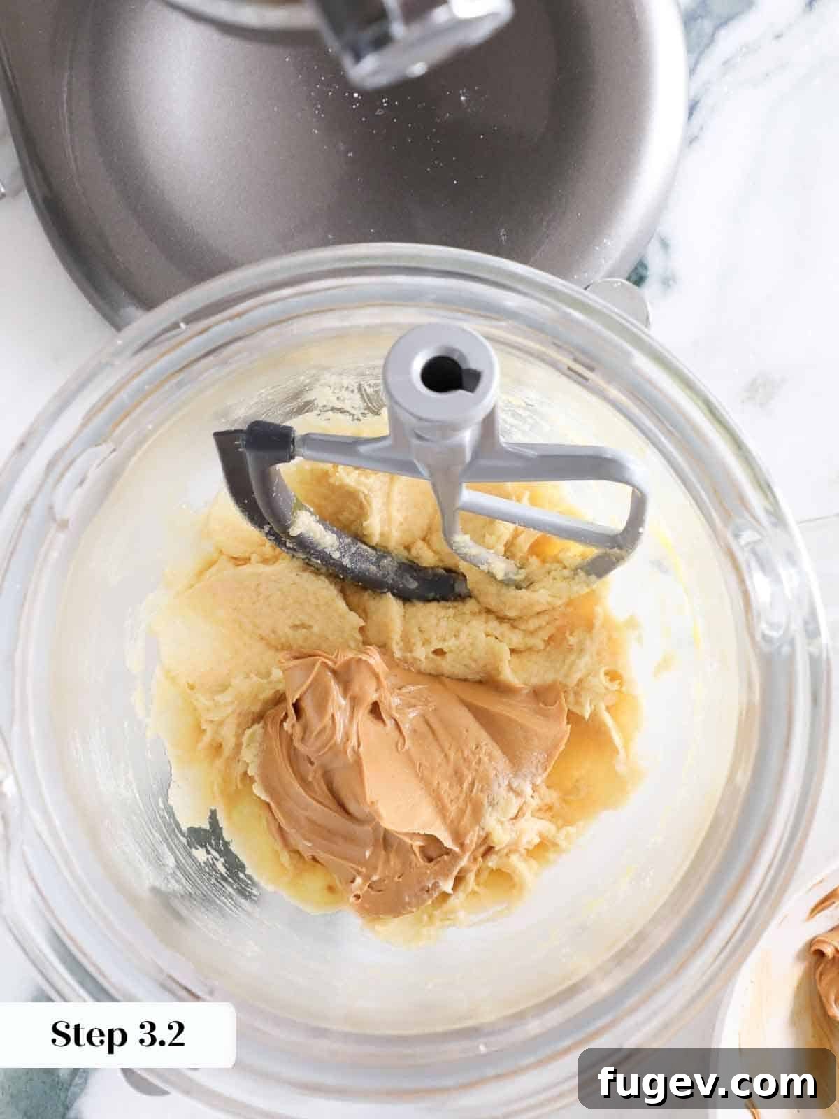Ultimate Monster Cookies 8 A spoonful of creamy peanut butter being added to a mixing bowl for monster cookie dough.