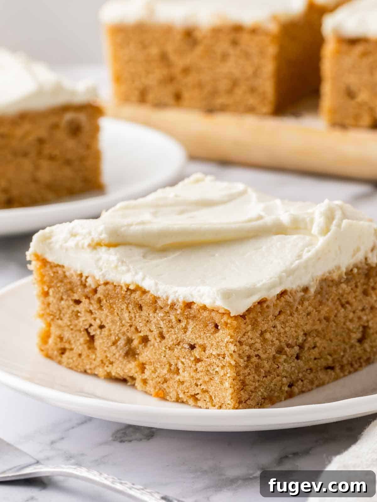 Luscious Banana Cake with Tangy Cream Cheese Frosting 2 A perfectly cut slice of moist banana cake generously topped with fluffy cream cheese frosting, highlighting its soft texture and inviting appearance.