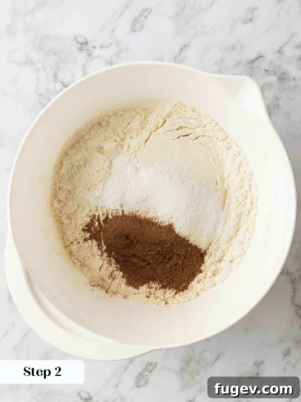 Luscious Banana Cake with Tangy Cream Cheese Frosting 5 A close-up shot of dry ingredients for banana cake, including flour, cinnamon, salt, and baking powder, unmixed in a bowl.